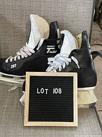 Pair of CCM men's black ice hockey skates size 10.5 positioned side by side showing exterior sides, white laces, and blades.