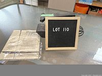 Vintage Craftsman belt sander displayed on table next to original user guide and small chalkboard sign with lot number.