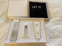Opened gift box showing Elizabeth Arden White Tea perfume bottle, smaller perfume vial, and lotion tube in original packaging.