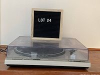 Front view of the Technics turntable with dust cover on, showing the unit and power cord.