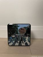 Front view of sealed Beatles 300 pieces jigsaw puzzle tin box with Abbey Road album cover image.