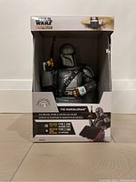 Front view of the box displaying the Mandalorian holding a gun, showing the phone and controller holder with product details.