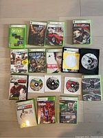 Photo of Xbox 360 games laid out on floor, displaying cases and discs of multiple titles.