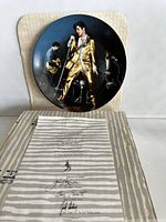 Front of the collector's plate showing Elvis Presley in gold suit performing.