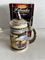 Front view of ceramic Labrador collectible stein with box, showing hunting dog scene and pewter lid with dog figurine.