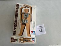 Box front showing the rope climbing doll mechanical model graphic with wooden frame and motor assembly.
