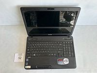Front view of Toshiba laptop opened, showing keyboard and screen, no power cord visible