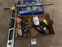 Overview of the lot showing the Dremel rotary tool with various attachments, the Brinks lock set, the 12-in-1 magic precision screwdriver box, and the builder's level.
