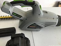 Photo of the EGO cordless leaf blower and one battery charger on a white table.