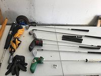 Assorted clubs laid on table with umbrella, headcovers and loose grips