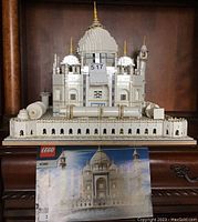 Front view of the mostly assembled LEGO Taj Mahal model with instruction booklet visible in front.