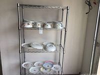 Metal shelving unit displaying various Lenox porcelain bowls and plates
