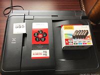 Top view of Canon PIXMA TR8520 showing branding label and bundled ink cartridges in original packaging.