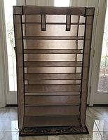 Front view of the 9-tier shoe organizer showing the fabric cover and zipper closed.