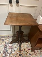 Full view of antique wooden side table showing square top surface and base