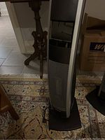 Front view of the Bionaire tower heater, showing the heating vents and base on a patterned rug.