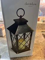 Photo of the Clair de Lune Ambiance lantern in its original box showing the lantern design and branding.
