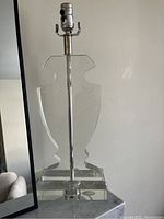 Clear glass lamp with abstract sculptural shape and heavy rectangular glass base, metal stem, no shade