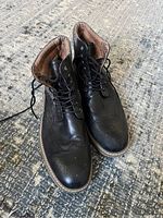 Pair of men's black leather ankle boots size 12, showing toe and top details with laces tied.
