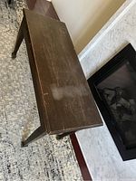 Top view of wooden piano bench showing surface wear and white staining.
