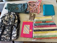 Overview of all six items including purses, pouches, backpack, wallet, and iPad mini case