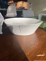 Side view of the white ceramic bowl showing textured exterior lines and shape