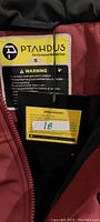 Close-up photo of the interior label showing brand PTahdus, size Small, and warning safety instructions about battery usage.