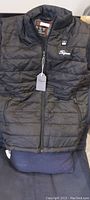 Front view of black quilted Telguus heated vest with zipper and logo on chest.