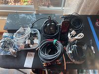 Panasonic Blu-ray player with cables and phones spread out on a table by a window