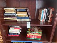 Two wooden shelves of books including spiritual books and Southern Living annual recipe cookbooks.
