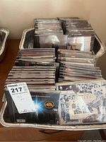 Photo showing multiple trays filled with CDs organized in rows. Front CDs include The Beatles collection and Christmas music albums.