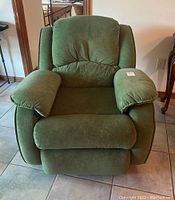 Front view of green ultrasuede rocker recliner chair on tiled floor.