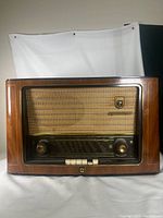 Front view showing wooden cabinet, cloth speaker grille, tuning scale and knobs