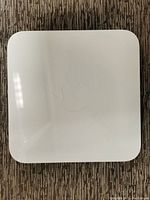 Top view of Apple AirPort Extreme Base Station showing white plastic surface with minor scuffs.