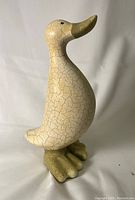 Front view of ceramic duck showing crackled glaze and greenish beak and feet.