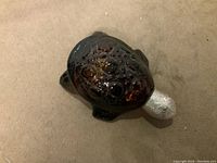 Top view showing detailed shell pattern and amber glass texture of turtle figurine perfume bottle.