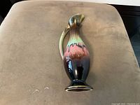 Side view of a mid century German Delph pottery ewer vase with drip glaze finish showing multicolor glossy ceramic surface and curved handle.