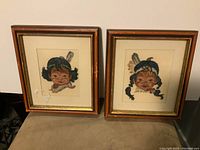 Full view of the two framed Native American needlepoint portraits featuring a girl and a boy, showing condition and framing details.