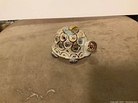 Front view of vintage pottery turtle figurine on flat surface