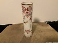 Front view showing detailed hand-painted cherry blossoms and birds around the circumference.