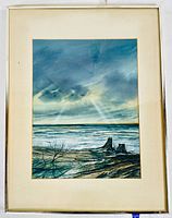 Frontal view of the framed watercolour painting depicting a cloudy coastal landscape with driftwood and ocean waves.