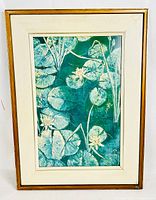 Full view of framed painting showing water lilies and leaves on dark water with canvas border and wooden frame