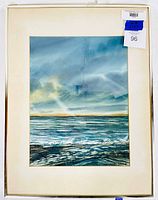 Full view of the framed watercolour painting showing seascape under cloudy sky with reflections in water, artwork centered with cream mat and under glass in metal frame