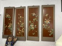 Set of four vertical rectangular oriental decorative wall screens with hand-painted birds and floral motifs on wooden panels, bordered with gray patterned fabric.