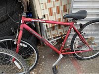 Side view of red Roadmaster RM Accelerate bicycle showing frame decal, pedal, and front tire.
