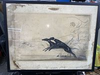 Full view of the framed vintage art print portraying woman pulled by two black dogs, showing overall condition including discoloration and staining.