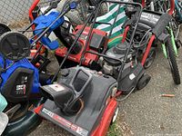 Two snowblowers, Huskee and Toro, stacked closely outdoors with visible labels and engine details
