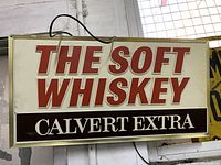 Front view of illuminated bar light sign with soft whiskey text
