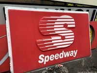 Full front view of large red Speedway gas station sign with embossed white logo and lettering.