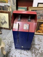 Front view of the vintage coin-operated sticker machine featuring Mickey and Minnie Mouse stickers with coin slots and levers